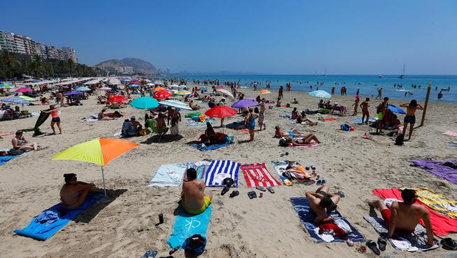 Turistas disfrutan de un soleado día en la playa del Postiguet, este sábado en Alicante.