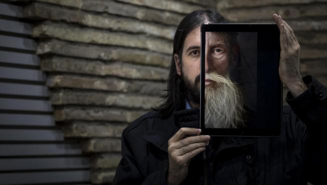 El zaragozano Jaime Sanjuán, con el iPad en el que pinta con sus dedos, en el que puede verse el detalle de una de sus obras.