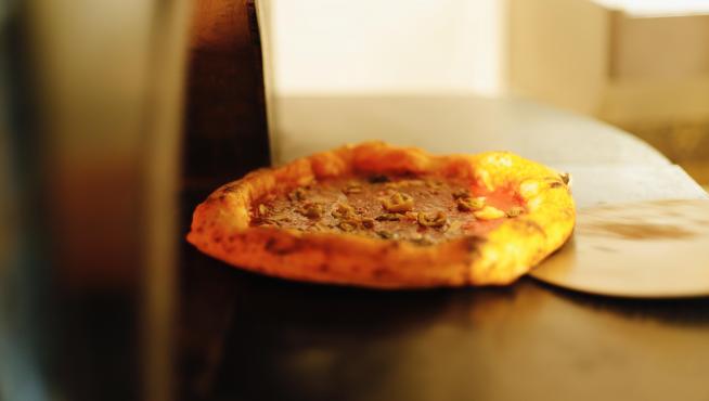 Una pizza napolitana recién sacada del horno de La Parthénope.