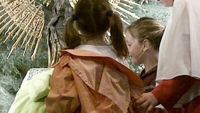 Varios niños visitan el manto de la Virgen en una imagen de archivo.