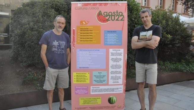 Javier Acín y Jorge Mur, en la plaza Biscós, junto a la programación cultural del Consistorio jaqués para el mes de agosto.