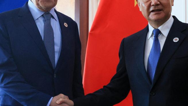Los ministros de Exteriores de Rusia y China se estrechan la mano.