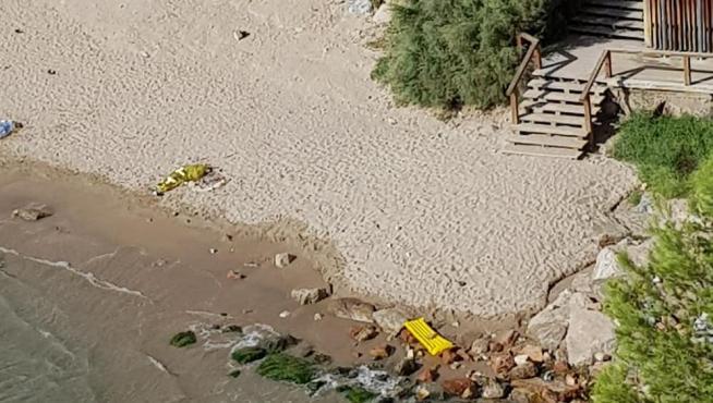 Los dos cadáveres yacen cubiertos sobre la arena en la playa de Salou