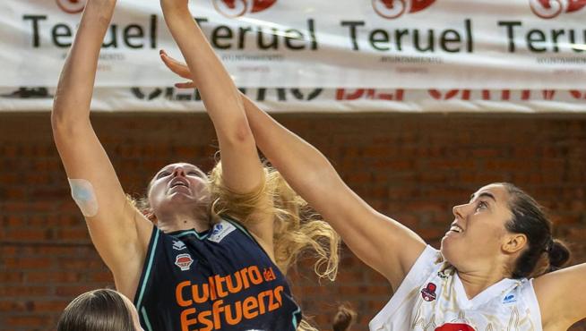 Vega Gimeno trata de taponar el lanzamiento de una jugadora de Valencia Basket, durante el amistoso disputado en Teruel.