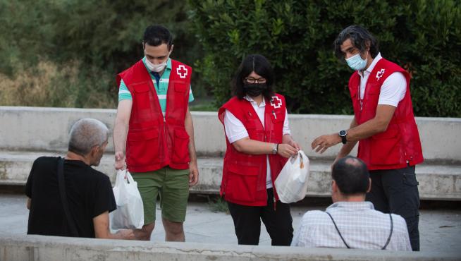 Un equipo de Cruz Roja atiende a dos transeúntes este pasado agosto, en plena ola de calor