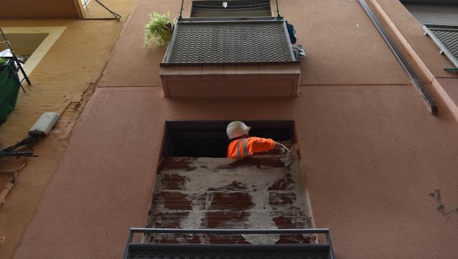 Un operario tapia las ventanas de un edificio okupado en la calle de Mariano Cerezo, donde se produjeron dos incendios en 2021.