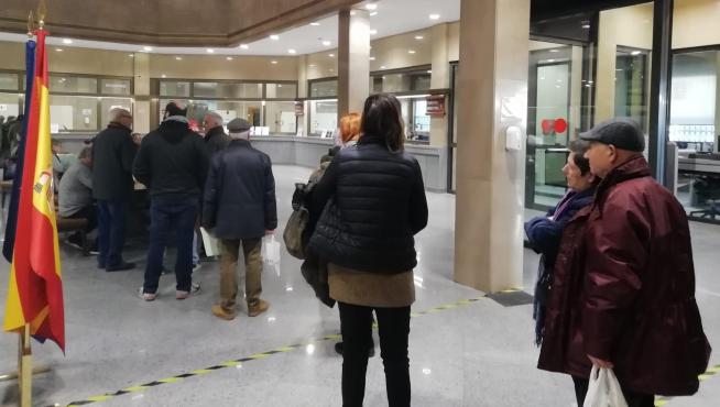 Personas esperando en el hall de la sede del Banco de España, este jueves en Zaragoza.