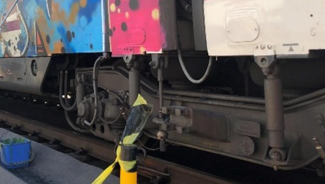 Operarios limpian una de los trenes vandalizados con grafitis.