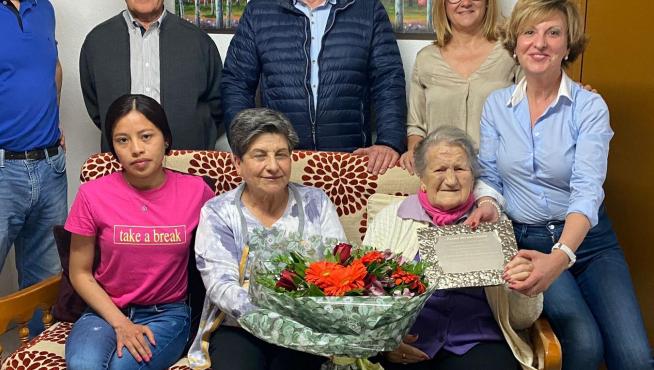 El alcalde Toño Ferrer y la teniente de alcalde, María Clusa, le entregan un ramo de flores y una placa.