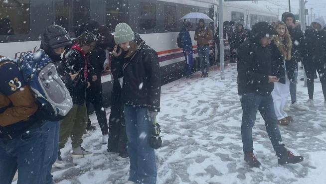 Los pasajeros en la parada de Grisén tras llevar horas parados a causa de la nieve.