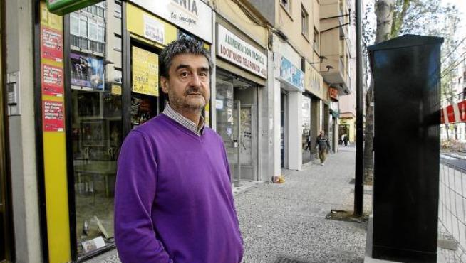 Alfonso Bernalte, junto a uno de los dos armarios que tapan la fachada de su tienda, Fotogenia.