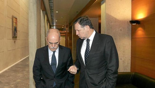 El consejero de Economía y Hacienda, Alberto Larraz, conversa con el presidente de la DGA, Marcelino Iglesias, en las Cortes.
