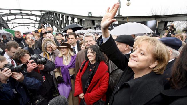 Merkel saluda a la multitud mientras cruza simbólicamente el antiguo paso de la calle Bornholm en Berlín.