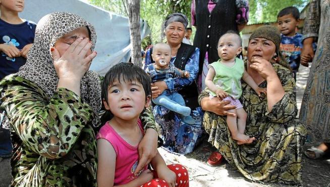 Refugiadas uzbekas con niños esperan en la frontera con Uzbekistán, a siete kilómetros del distrito uzbeko de Osh, ayer.