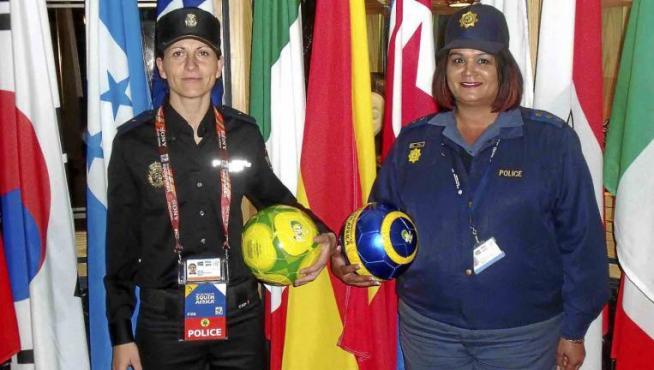 Silvia (a la izquierda), con una policía sudafricana, en el interior del estadio de Pretoria, donde ayer jugó España contra Chile.