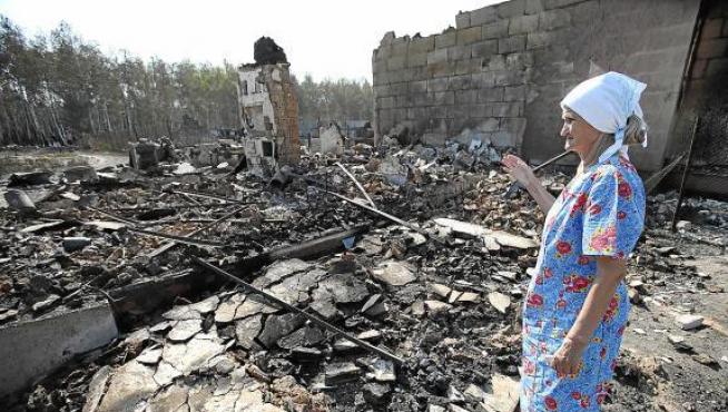 Una mujer mira su casa reducida a escombros por el fuego en Voronez, Rusia.