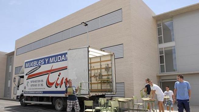Los operarios de la mudanza transportan mobiliario al nuevo centro.
