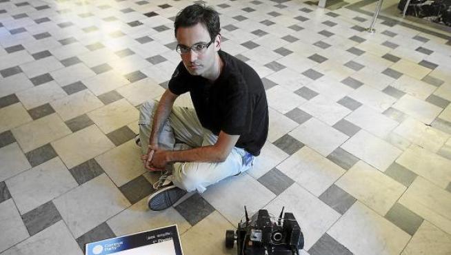 David Meléndez, sentado en el suelo con su robot y el diploma que ganó en Valencia.