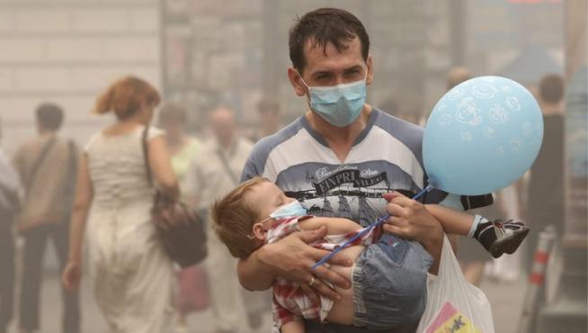Un par de viandantes se protegen de la contaminación ambiental con mascarillas en el centro de Moscú