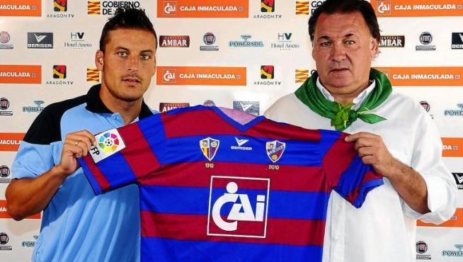 Marco Navas coge la camiseta del Huesca en compañía del vicepresidente de la entidad azulgrana, Agustín Lasaosa.