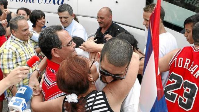 Marcelo Cano (en el centro, con gafas) besa a un familiar a su llegada a Madrid, el martes.