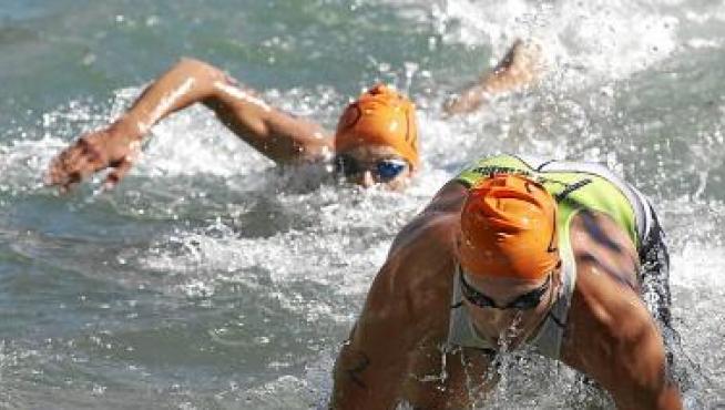Dos participantes nadan en la primera prueba del triatlón.
