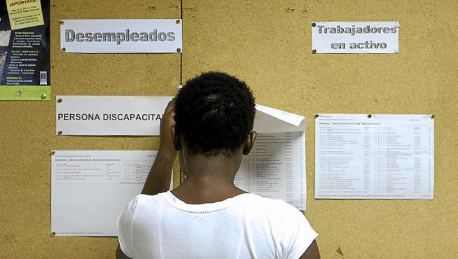 Una mujer mira las ofertas de trabajo y formación en una oficina de empleo.