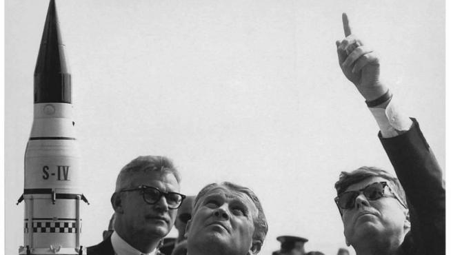 científico alemán Wernher von Braun (2i) al explicarle al entonces presidente estadounidense John F. Kennedy (d) el sistema de lanzamiento de cohetes hacia Saturno