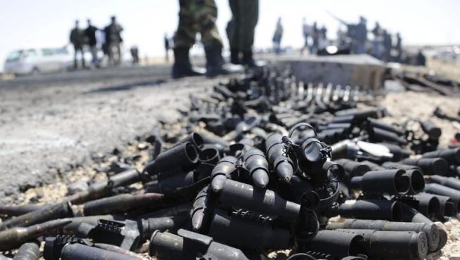 Rebeldes libios junto a munición destruida en una carretera que conduce a Briga