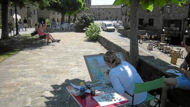 Un concurso de acuarelistas en el que una de las participantes pinta la torre y la plaza Mayor de Aínsa.