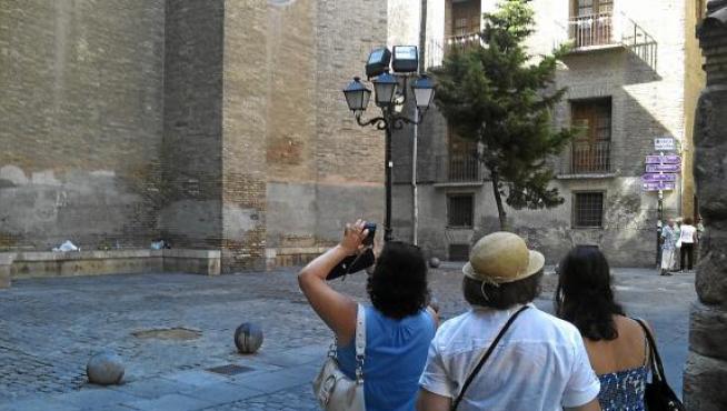 Tres turistas británicas fotografiaban ayer La Seo, en la calle de Dormer, entre restos de botellón.