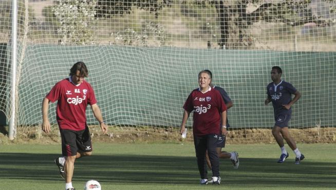 Gilvan hace carrera continua mientras el míster, Quique Hernández, da indicaciones a otros futbolistas.