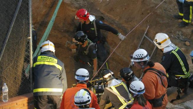 Los bomberos tratan de rescatar a un obrero herido