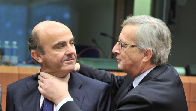 Jean-Claude Juncker y De Guindos bromean durante la reunión