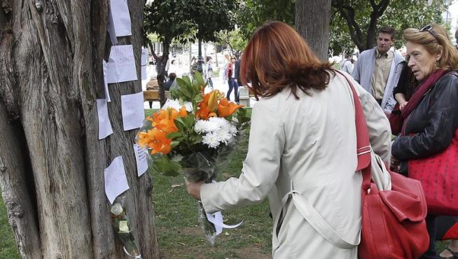 Una mujer deja un ramo de flores en el lugar de un suicidio, en Grecia.
