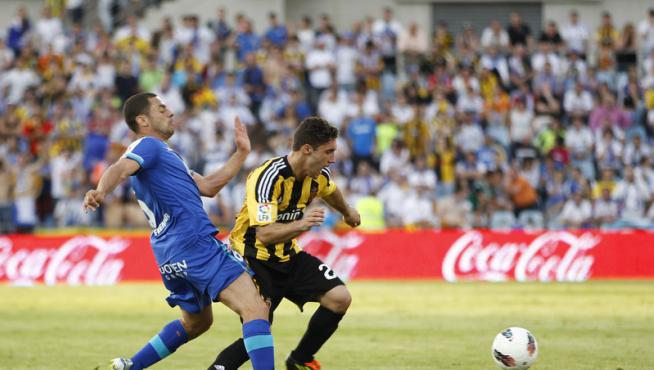 El defensa del Getafe CF Rafa López (d) pugna por el balón con el argentino Franco Zuculini