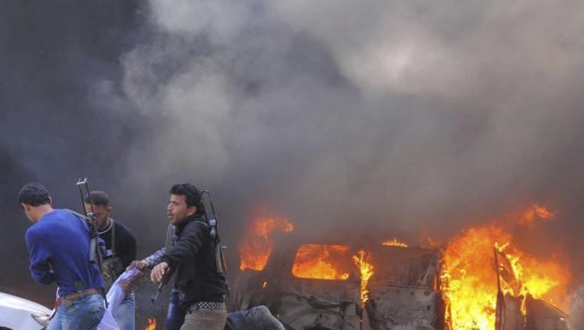 Tres rebeldes sirios llevan en volandas a un herido en el atentado en Damasco.