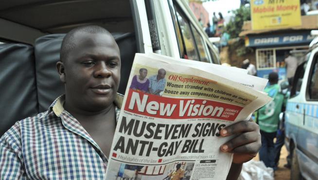 Un hombre lee un periódico que trata la 'ley anti-gay' ugandesa