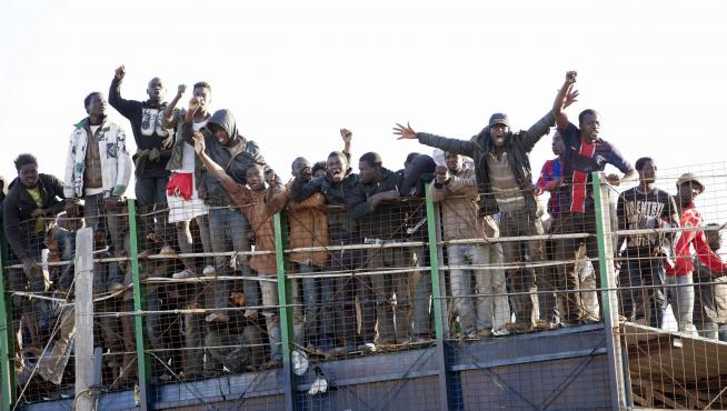 Inmigrantes intentando saltar la valla