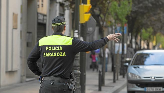 Un policía local regula el tráfico en una calle del centro de Zaragoza.
