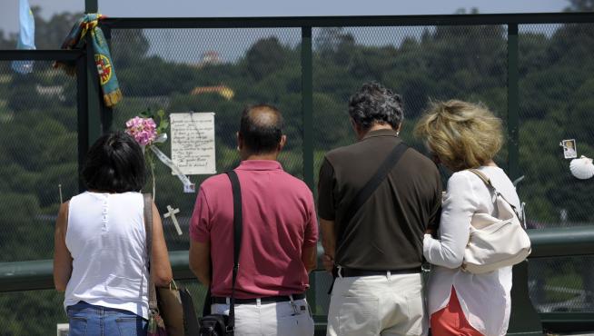 Varias personas recuerdan a las víctimas en el lugar del accidente.