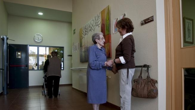Una anciana en la residencia junto a un familiar