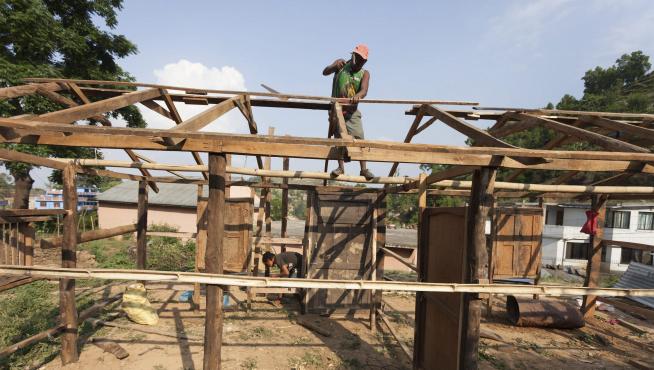 Un hombre trabaja en la construcción de un refugio temporal.