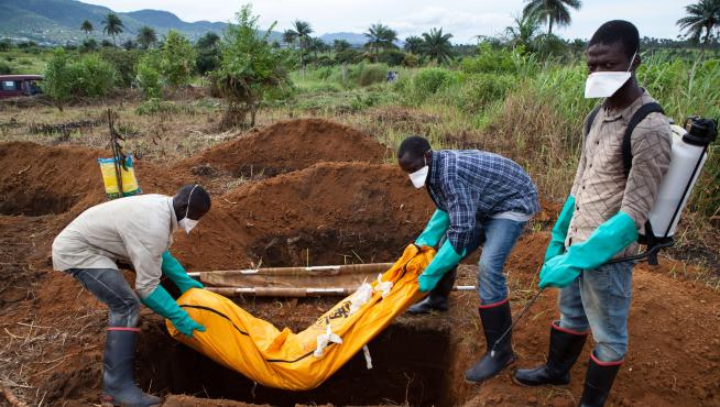 Varios voluntarios con el traje de seguridad entierran el cuerpo de un fallecido en Waterloo, al sureste de Freetown, en una imagen de archivo.