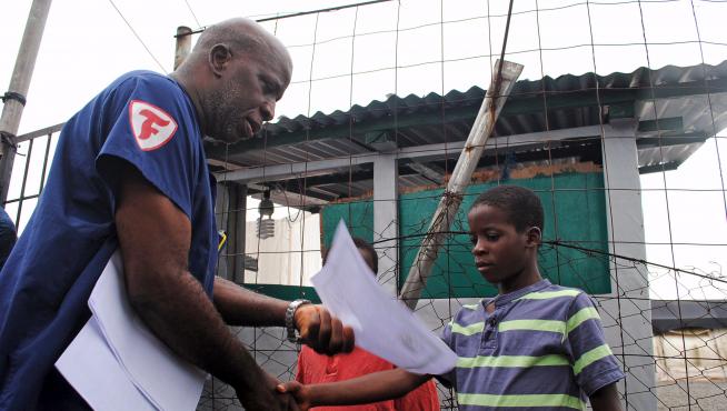 Un niño recibe en Liberia el certificado que acredita que está curado de ébola.