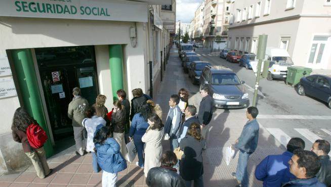 Unos ciudadanos guardan fila ante una oficina de la Seguridad Social.