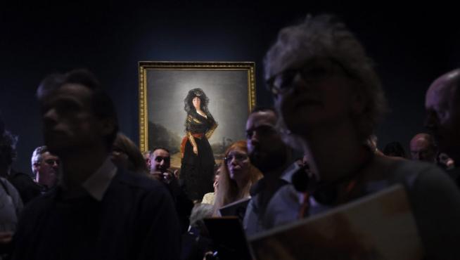 Visitantes de la exposición de retratos de Goya en la National Gallery de Londres, con el cuadro de la Duquesa de Alba de luto al fondo.
