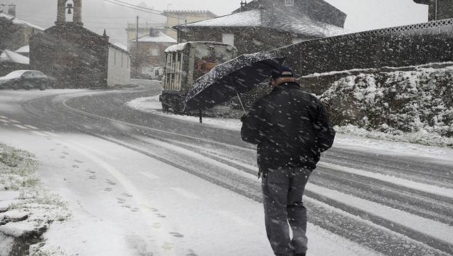 Un vencino de O Cádavo, en Lugo, se protege de la nieve.