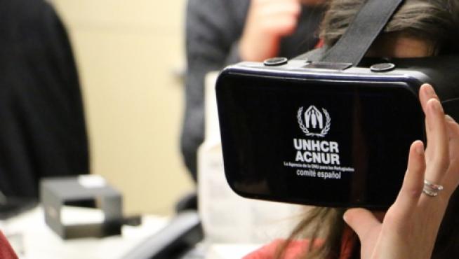 Una usuaria con las gafas de realidad virtual del Comité español de ACNUR.