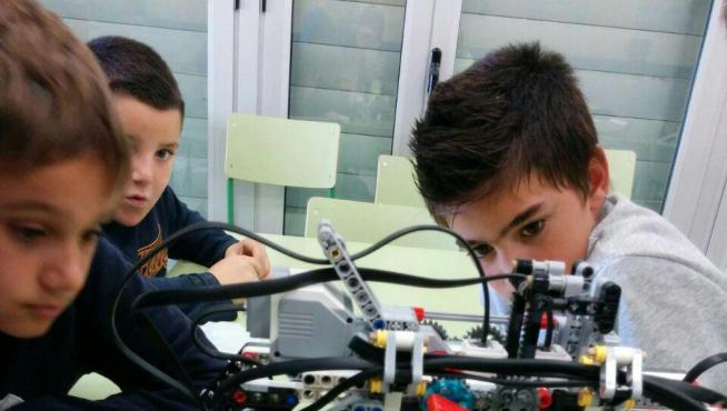 Unos niños disfrutan del taller de robótica en Huesca.
